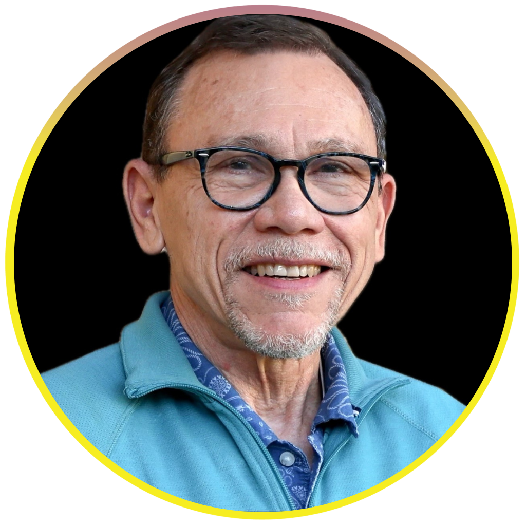 Dr. Ronald Garth Smith is wearing a blue collared shirt. He has short, grey hair and a grey mustache. He is smiling for a professional headshot in front of a black background. There is a yellow and orange ring around his photo.